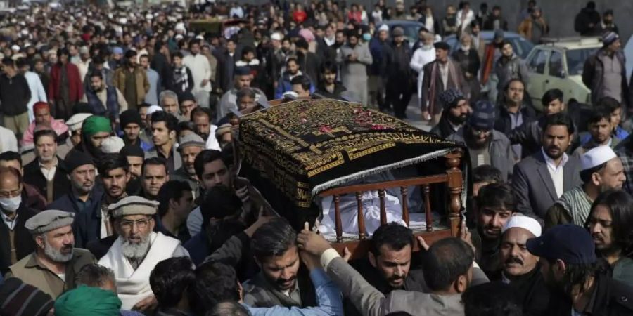 Die Leichen einer Familie werden zu Grabe getragen. Nach einem heftigen Wintereinbruch im Norden Pakistans sind mindestens 22 Urlauber ums Leben gekommen. Foto: Rahmat Gul/AP/dpa