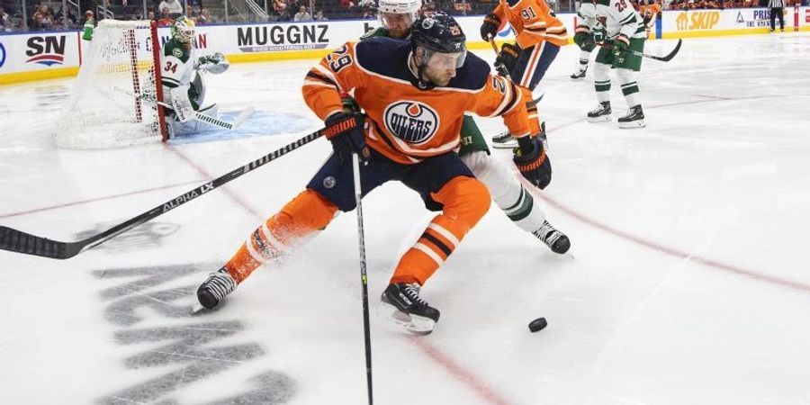 Alex Goligoski (2,M) von den Minnesota Wild jagt Leon Draisaitl (vorne) von den Edmonton Oilers. Foto: Jason Franson/The Canadian Press/AP/dpa