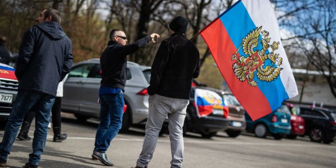 Ein Teilnehmer mit einer russischen Russische Flagge. Demo Ukraine Krieg