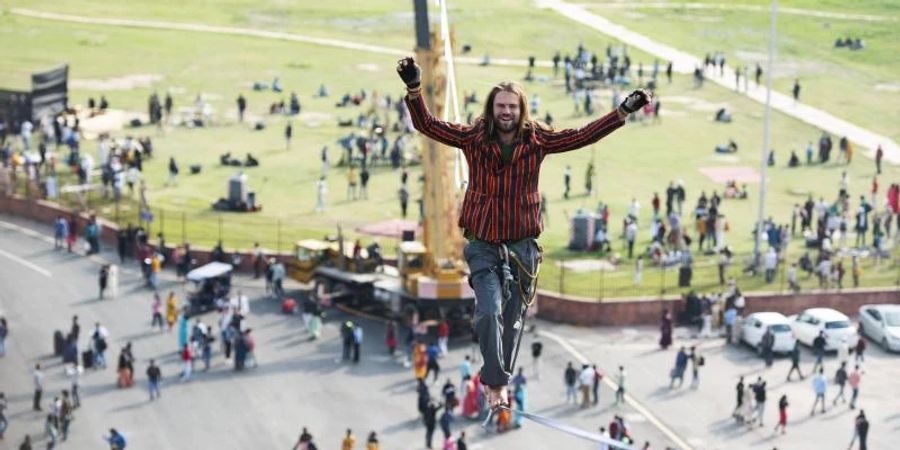 Alexander Schulz läuft in 30 Metern Höhe in Neu Delhi vor dem Palast und UNESCO-Weltkulturerbe Red Fort über die Slackline. Foto: Azra Sadr/Deutsche Botschaft Neu Delhi/dpa