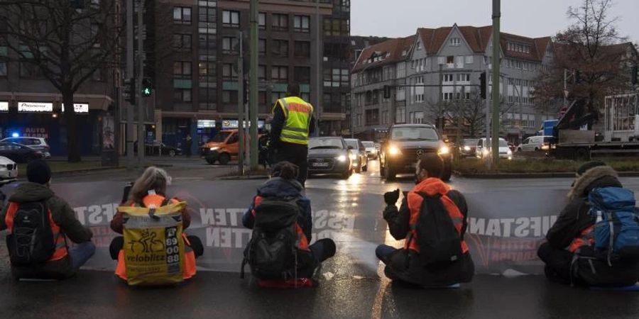 Aktivisten einer Gruppe, die sich «Aufstand der letzten Generation» nennt, blockieren in Berlin-Steglitz die Autobahn-Zufahrt. Foto: Paul Zinken/dpa