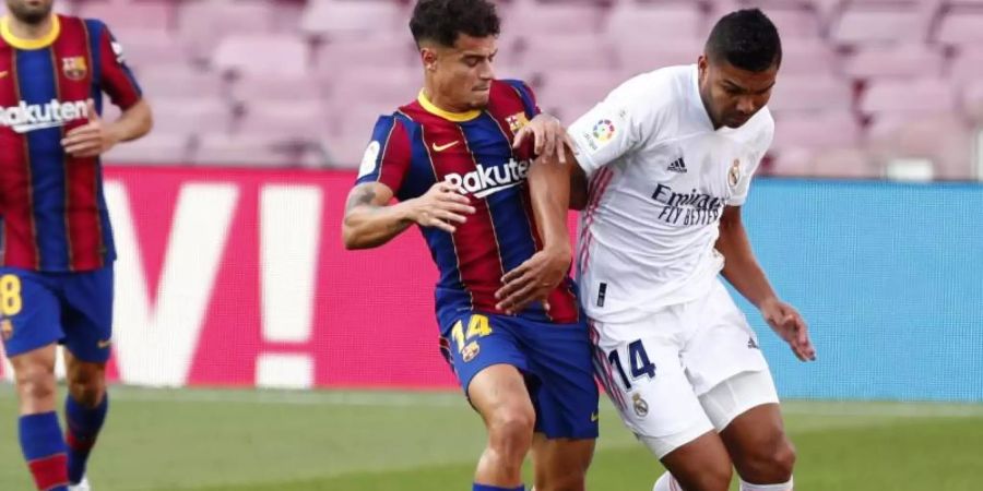 Real Madrids Casemiro (r) und FC Barcelonas Philippe Coutinho (l) beim Kampf um den Ball mit. Foto: Joan Monfort/AP/dpa