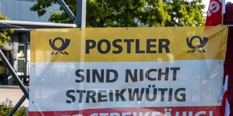 «Postler - Sind nicht streikwütig aber streikfähig!»" steht auf einem Plakat vor dem Briefzentrum der Post in Straubing. Foto: Armin Weigel/dpa