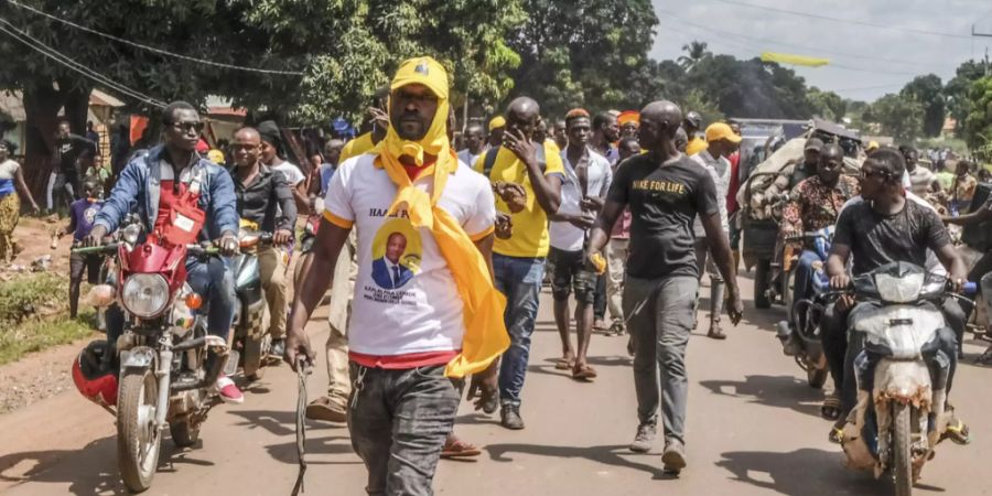 Anhänger der Regierungspartei «Partei des Volkes von Guinea» demonstrieren gegen die Opposition. Foto: Sadak Souici/AP/dpa