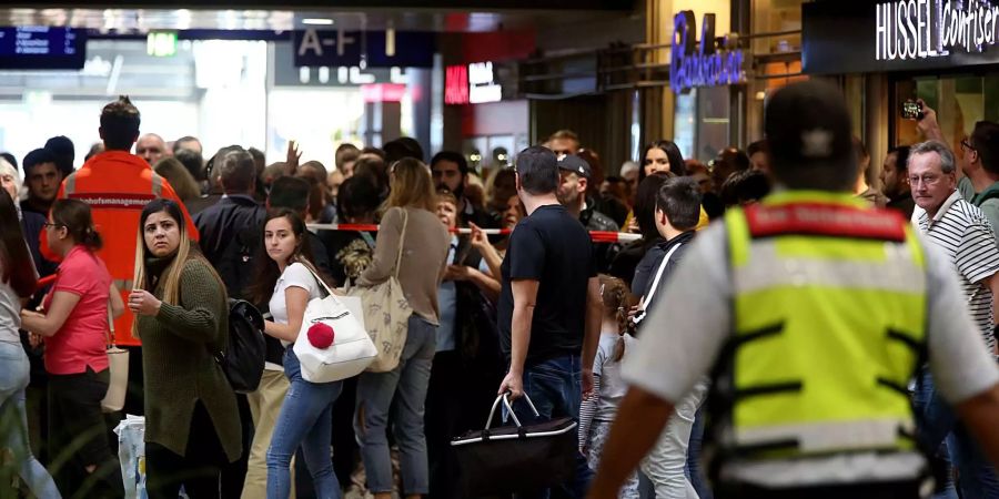 Reisende stehen im Kölner Hauptbahnhof.