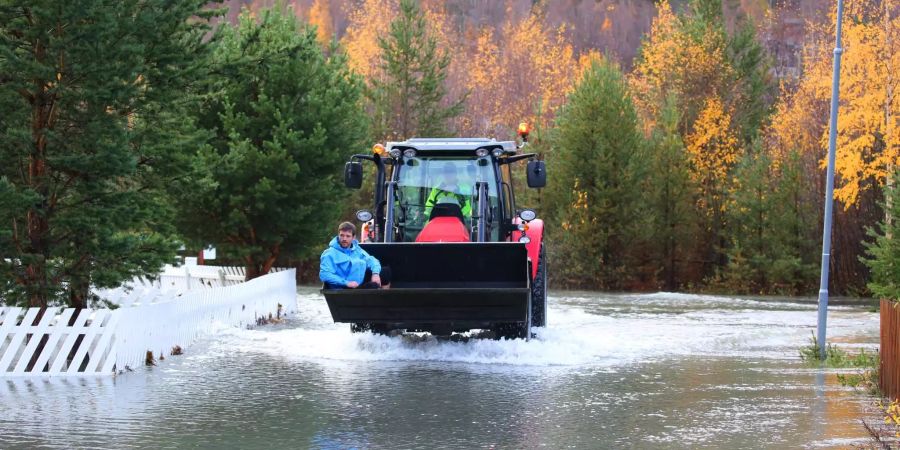 Trond Brandsar wird mit Hilfe eines Traktors zu seinem Haus in einem überschwemmten Gebiet in Bismo gebracht, etwa 400 km nördlich von Oslo.