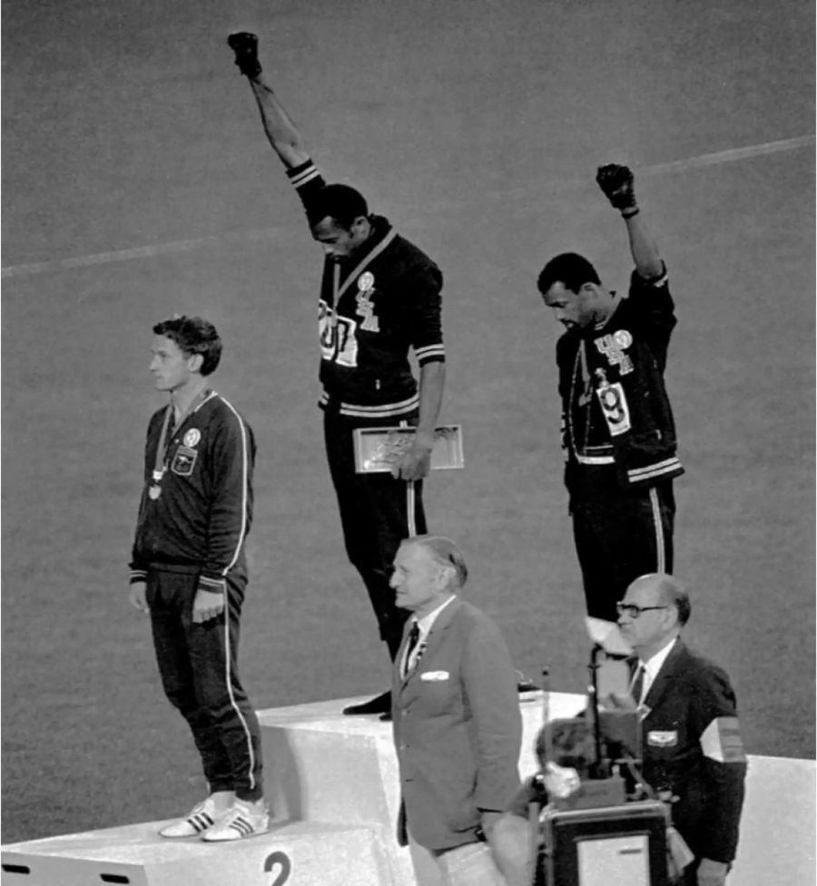 Tommie Smith (Mitte) und John Carlos (rechts) recken die Faust in die Luft. Links: Peter Norman (Australien).