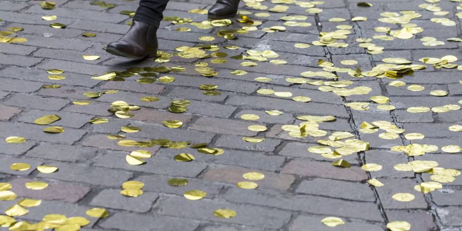 Frauenschuhe gehen über goldene Konfettis - Keystone