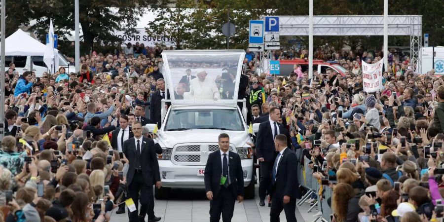 Papst Franziskus grüsst auf seinem Weg zum Platz die Gläubigen aus dem Papstmobil.