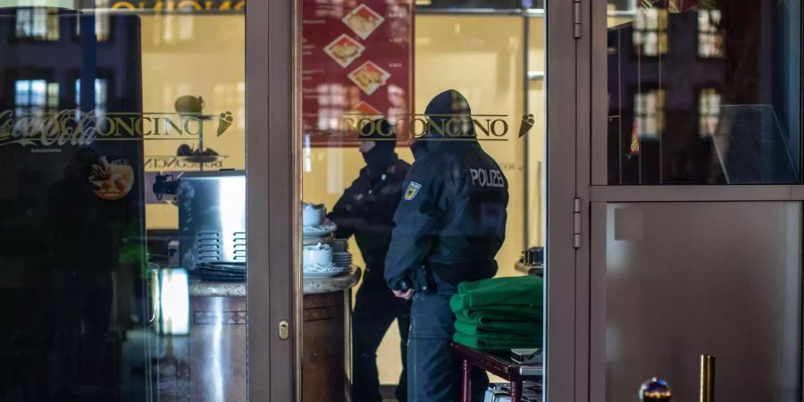 Polizisten stehen in einem Eiscafé im Citypalais in der Duisburger Innenstadt.