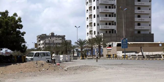 Ein Passant geht über eine menschenleere und autofreie Strasse in Hudaida.