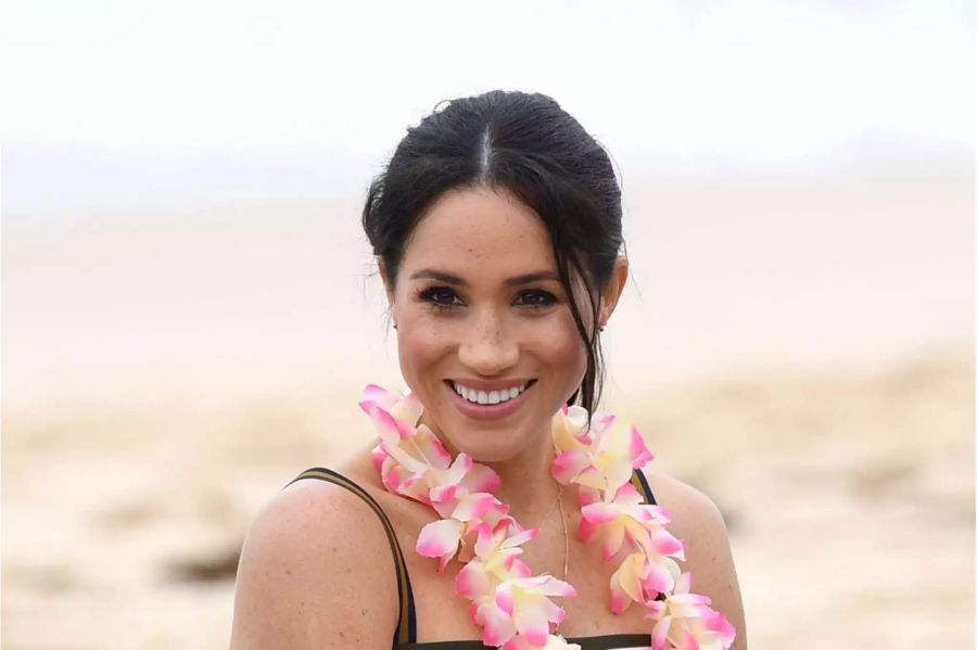 Meghan mit Sommerkleid und Blumenkette am Strand von Bondi Beach.