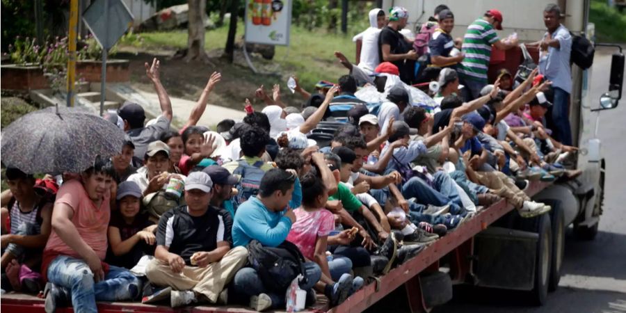 Migranten aus Honduras reisen auf einem Truck in die USA.