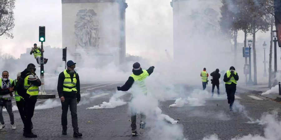 Demonstranten laufen durch eine Wolke von Tränengas.