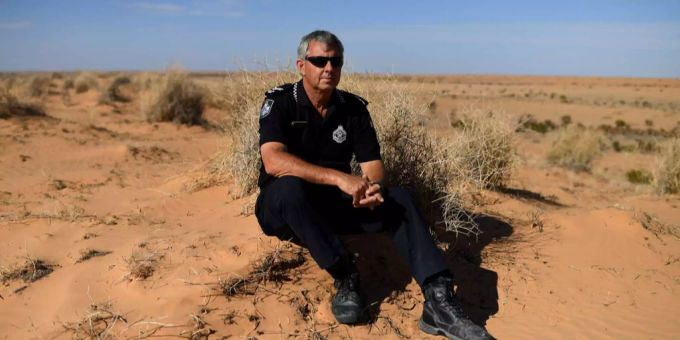 Der australische Polizist Stephan Pursell sitzt am Boden. Der australische Polizist Stephan Pursell sitzt am Boden.