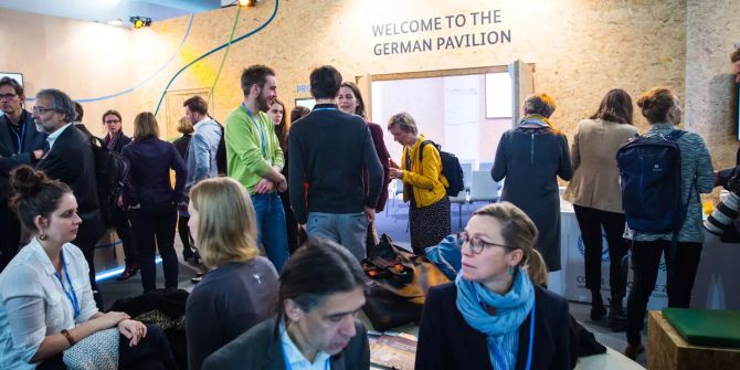 Teilnehmer sitzen auf der UN-Klimakonferenz bei der Eröffnung des Deutschen Pavillons.