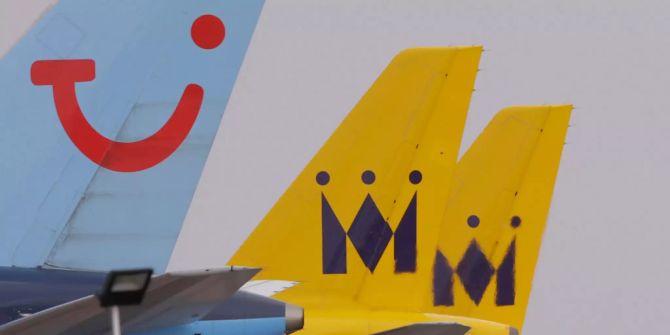 Ein Flugzeug von Tui nehmen zwei von Monarch Airlines.