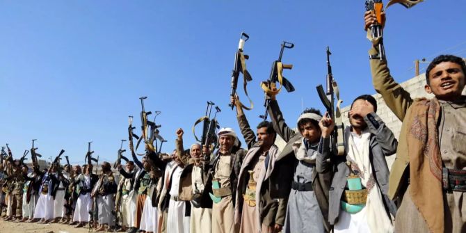 Anhänger der Rebellenbewegung Houthi halten während einer Versammlung Waffen aufrecht.