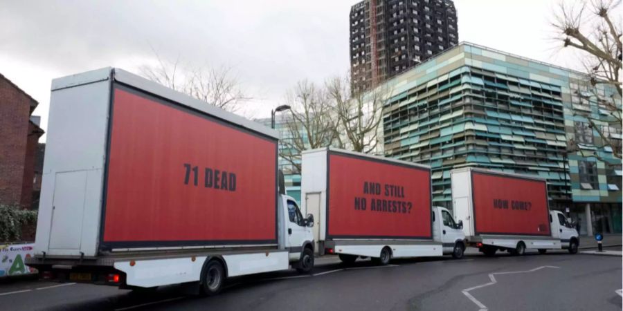 Three Billboards outside Grenfell, London (GB). Im Hintergrund der ausgebrannte Wohnturm.