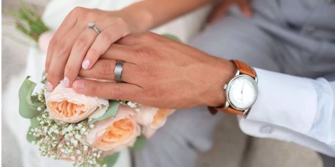 Just married: Zwei Eheleute zeigen ihre Trauringe. Coronavirus