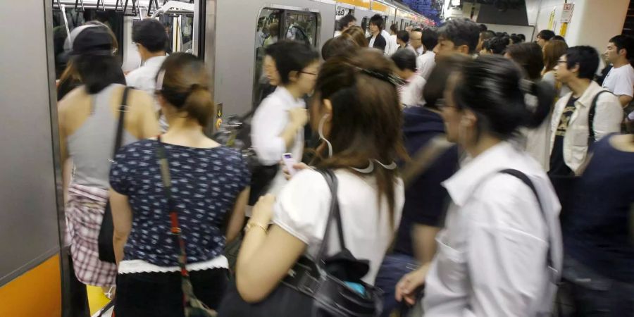 Szene im Bahnhof im Stadtteil Shinjuku in Tokio an einem Nahverkehrszug.