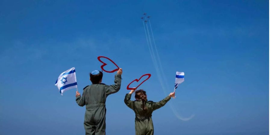 Israelische Kinder winken mit Fahnen einer Flugshow anlässlich des Unabhängigkeitstages zu