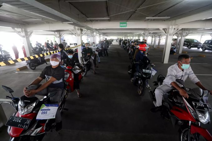 Impfwillige warten auf Motorrädern auf ihren Pieks. COVID-19 vaccination Jakarta