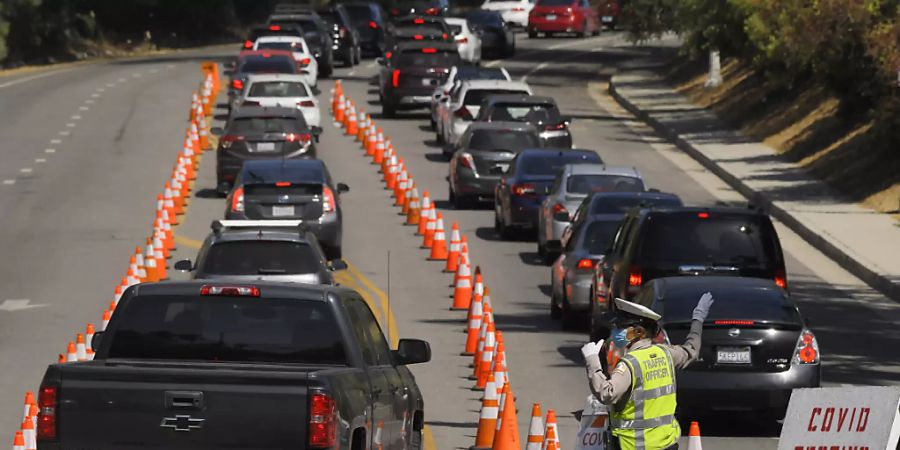 Fahrzeuge stehen vor dem Dodger Stadium in Los Angeles für einen Coronavirus-Test in einer Schlange. Foto: Mark J. Terrill/AP/dpa