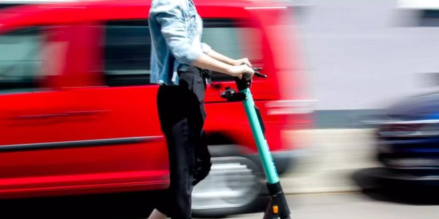 Eine junge Frau unterwegs mit einem E-Scooter in Hannover. Foto: Hauke-Christian Dittrich/dpa