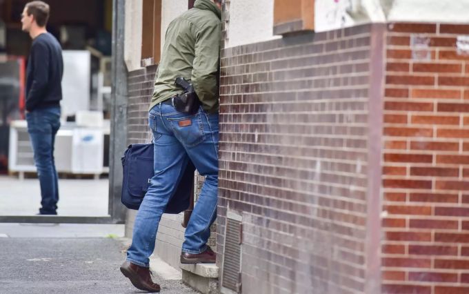 Ein Polizeibeamter betritt ein Haus in Bonn (D). Im Fall von zwei in einem Supermarkt schwer verletzten Polizisten sind am 13.05.2020 die Wohnungen von zwei Verdächtigen in Bonn und Troisdorf durchsucht worden. Wohnungsdurchsuchung in Bonn