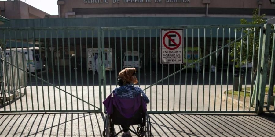 Wartende Frau vor Notaufnahme eines Hospitals in Santiago de Chile