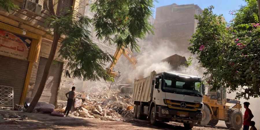 Anwohner und Rettungskräfte durchsuchen die Trümmer des eingestürzten Gebäudes in Kairo.