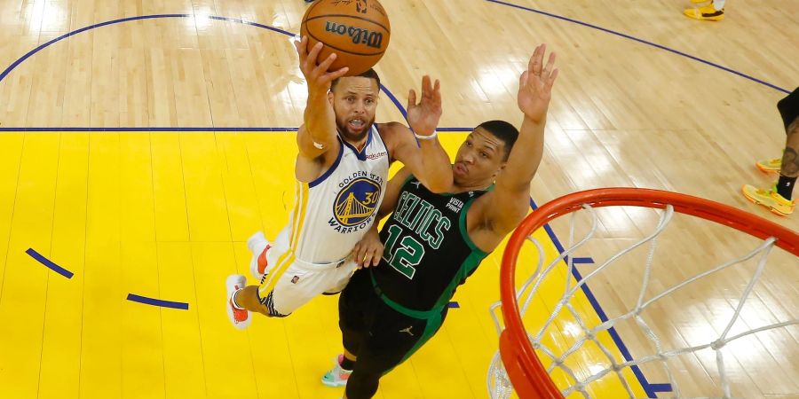 Golden States Stephen Curry (l) wirft neben Bostons Grant Williams.