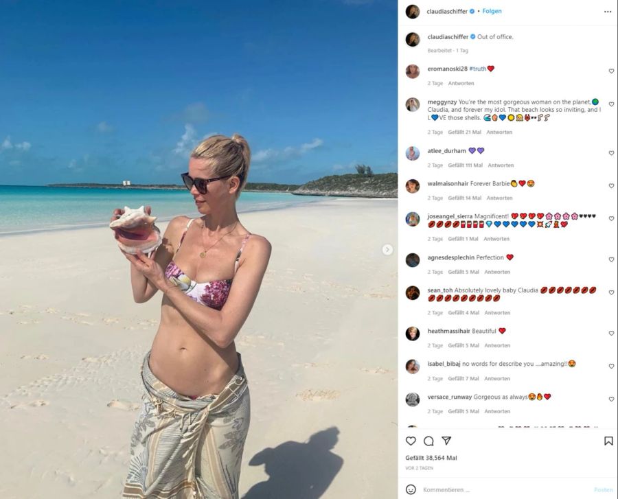 Claudia Schiffer posiert mit einer Muschel am Strand.