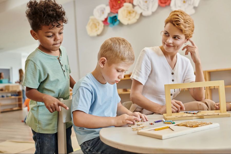 Kinder spielen, Frau beobachtet.