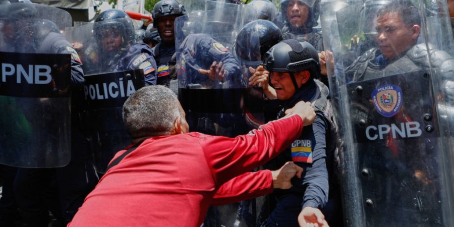 ARCHIV - Ein Demonstrant hält einen Beamten der Bolivarischen Nationalpolizei fest, als die Polizei versucht, die Demonstranten, die höhere Gehälter, Renten und Sozialleistungen ford...