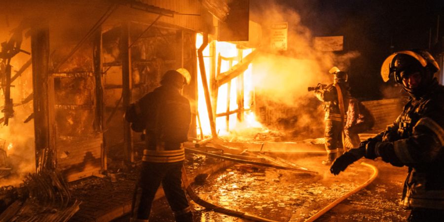 Feuerwehrleute arbeiten daran, die Flammen einzudämmen, die aus dem zentralen Markt in Kramatorsk aufsteigen, nachdem ein russischer Drohnenangriff das Gebiet in Brand gesetzt hat. Fot...