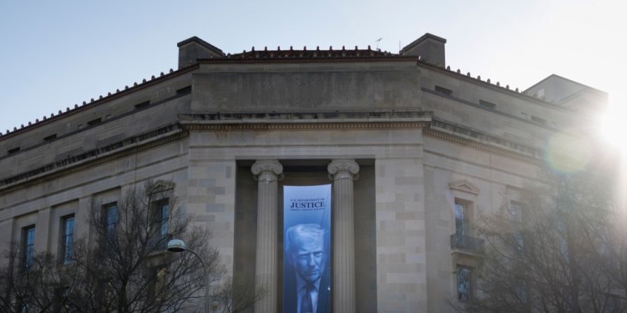 Ein Banner von Präsident Donald Trump hängt vor dem US-Justizministerium in Washington. Foto: Tom Brenner/AP/dpa