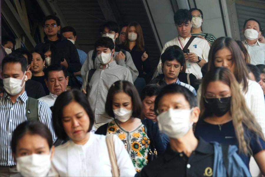 Pendler tragen Gesichtsmasken, um sich vor der Luftverschmutzung zu schützen.