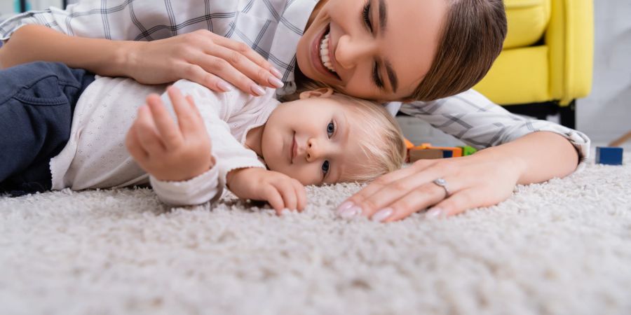 Mutter und Kind auf einem Teppich liegend