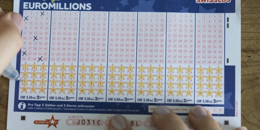 Eine Person füllt einen Euromillions-Spielschein von Swisslos aus. (Archivbild)