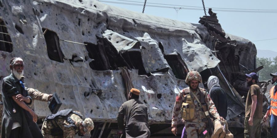 Sicherheitsbeamte untersuchen einen beschädigten Zugwaggon auf einem Bahngleis am Ort einer Bombenexplosion in Quetta. Foto: Arshad Butt/AP/dpa