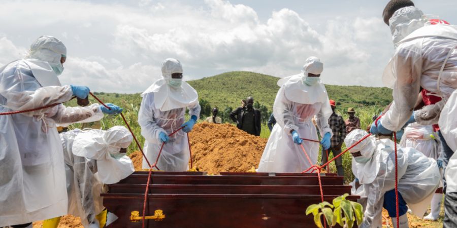ARCHIV - Mitarbeiter des Roten Kreuzes beerdigen ein Ebola-Opfer auf dem Rwampara-Friedhof. Foto: Moses Sawasawa/AP/dpa