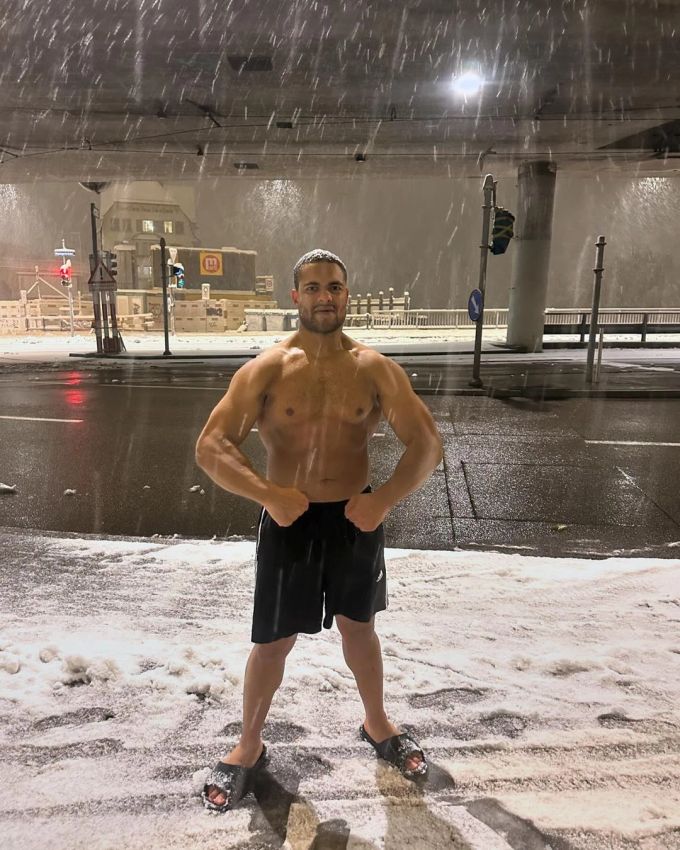 Kaltes Wetter macht ihm nichts aus: Brian Keller lässt in Shorts und Schlappen mitten im Schnee-Chaos seine Muckis spielen. wetter