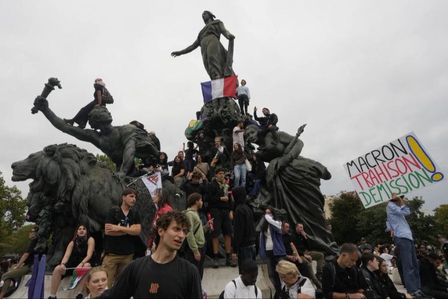 Demonstranten erklimmen die Nationalfigur Marianne.