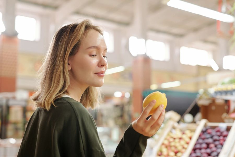 Frau mit Zitrone im Supermarkt