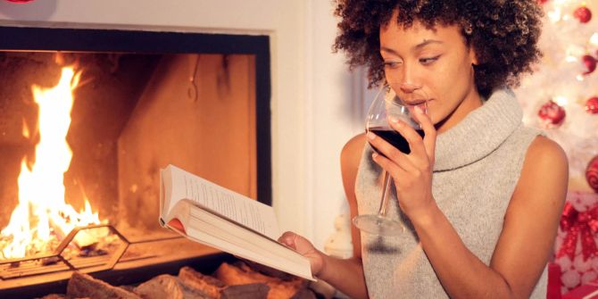 Frau trinkt Wein und liest ein Buch