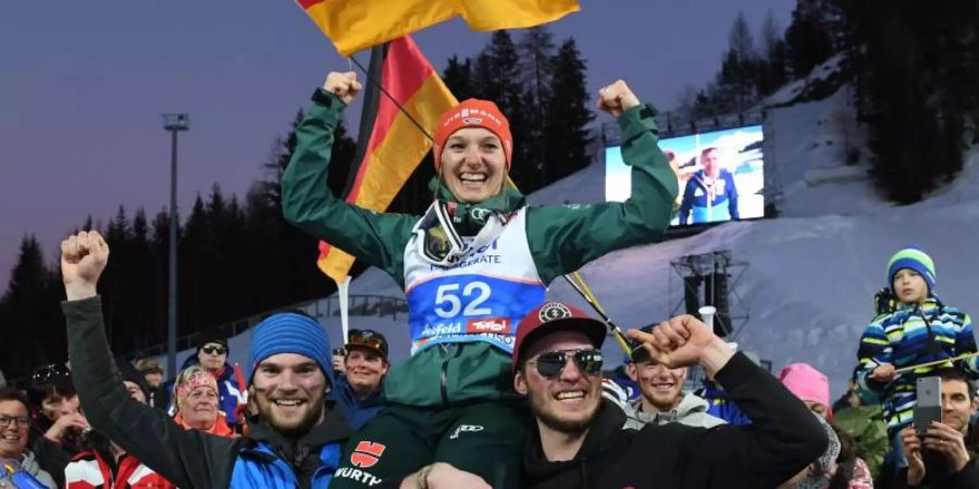 Katharina Althaus wird nach der Silbermedaille von ihren Brüdern auf Händen getragen. Foto: Hendrik Schmidt
