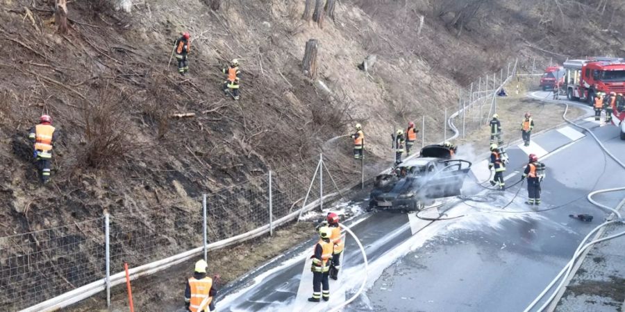 Die Feuerwehrleute mussten nicht nur den Autobrand löschen, sondern auch die Flammen auf der Böschung.