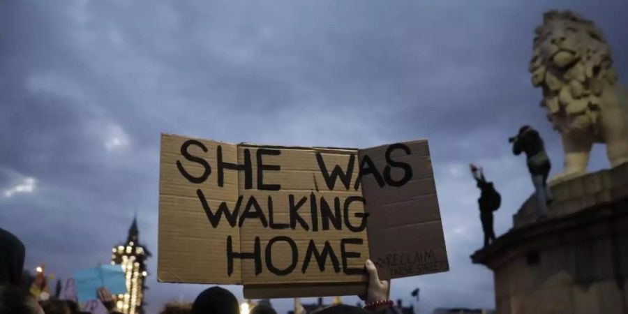 Eine Person hält inmitten einer Menschenmenge in der Nähe des Parlaments in London ein Plakat mit der Aufschrift «She was walking home» («Sie ging nach Hause») in die Höhe. Foto: Matt Dunham/AP/dpa